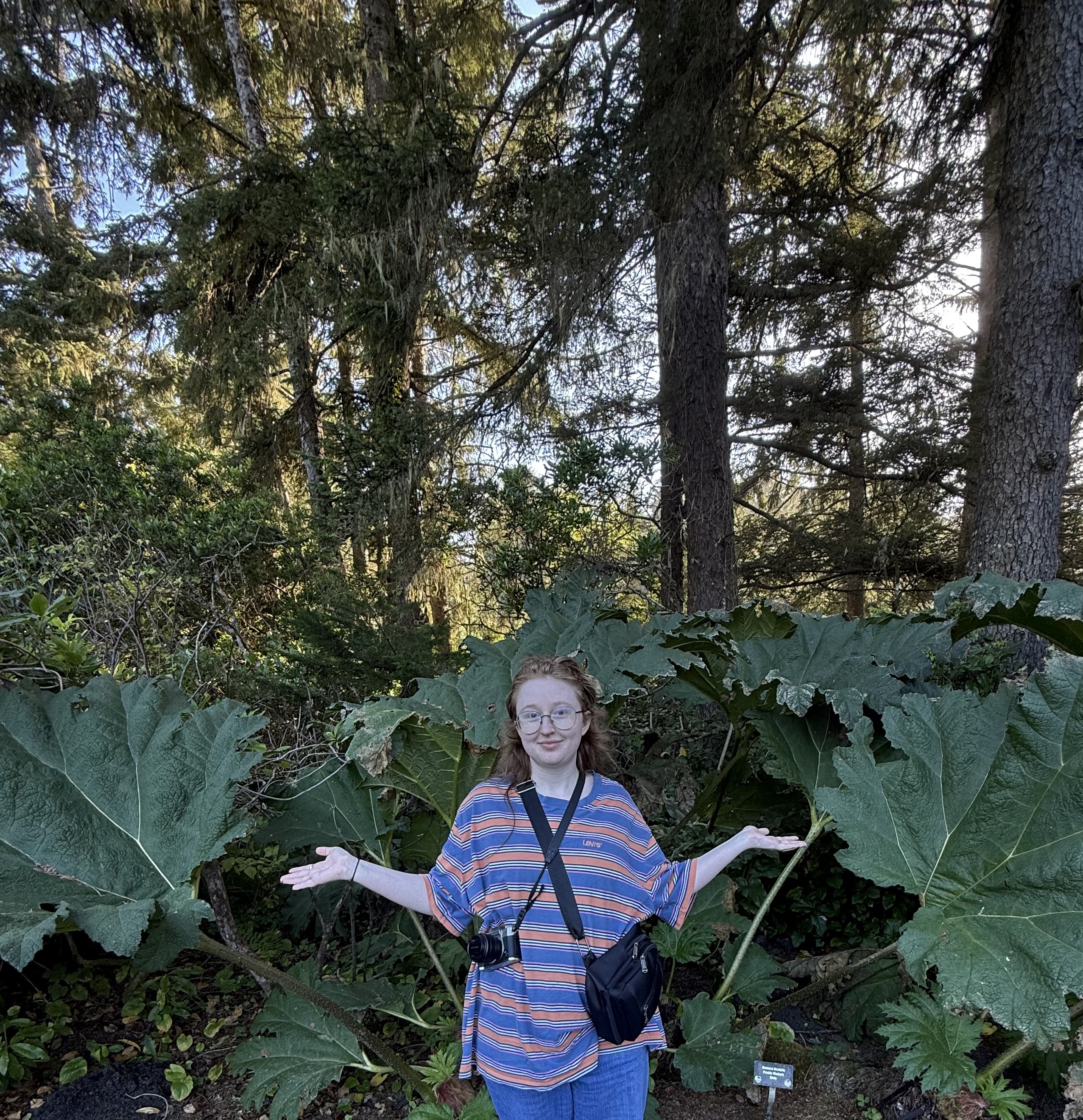 Casey Whitmire posing in front of large foliage